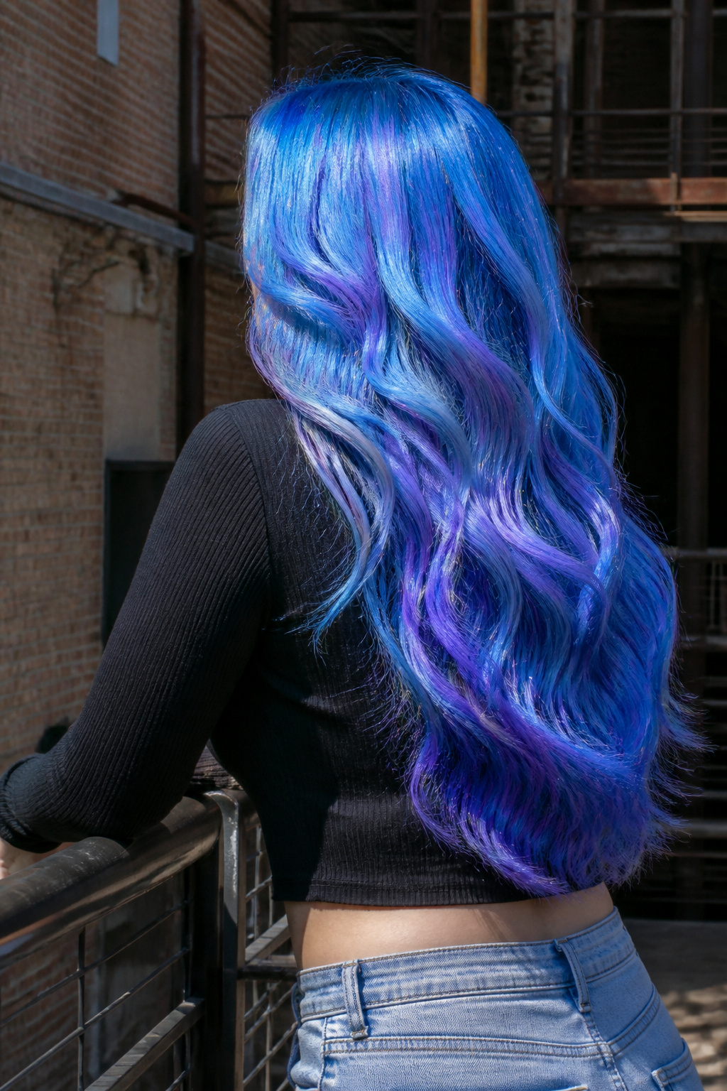 Best Holographic Hair Ideas: Colors, Styles and Techniques for 2026 15 Model with electric blue hair in a stylish urban environment.