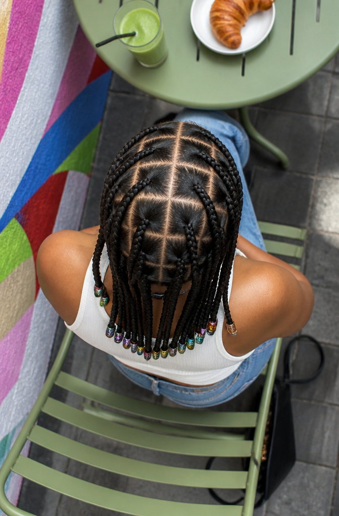 20 Pretty Hairstyles with Braids for 2026 5 Woman with box braids styled in small, square sections in a park.