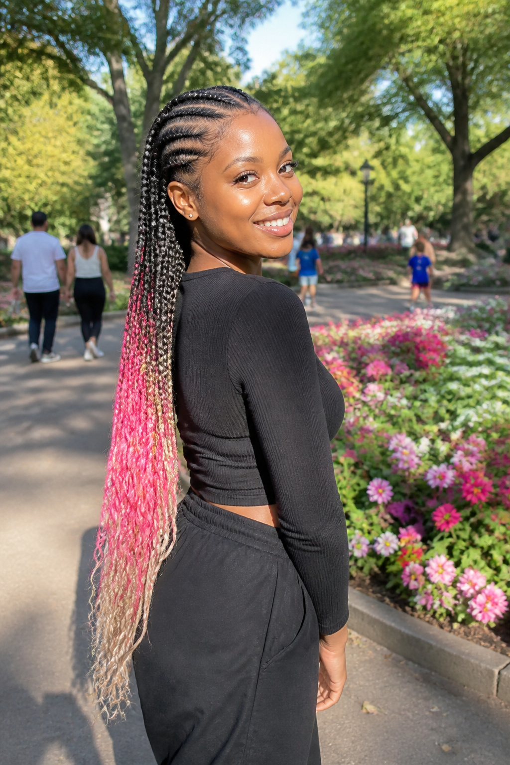 A young Black woman with colorful feed-in braids framing her face.